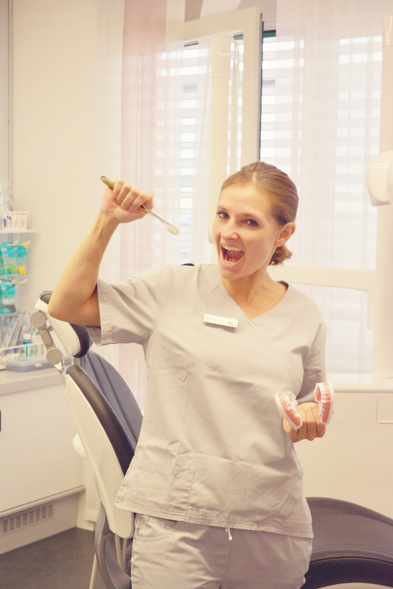 Mira Caspari in der Praxis mit Zahnbürste und Zahnmodell